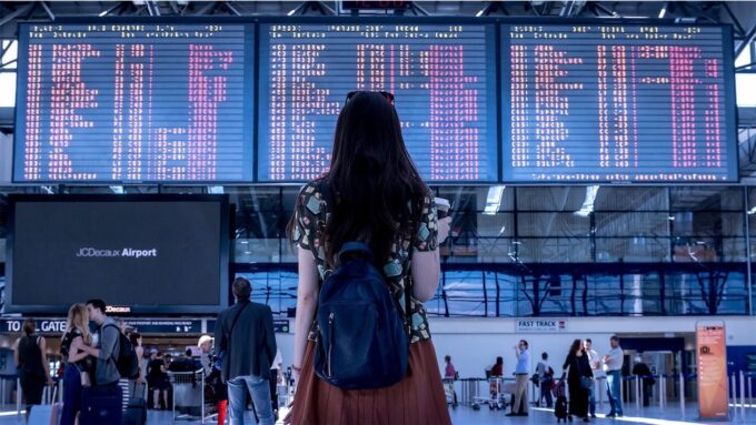 空港で掲示板を確認する女性