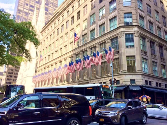 ニューヨークの建物の外に立ち並ぶアメリカの国旗の写真